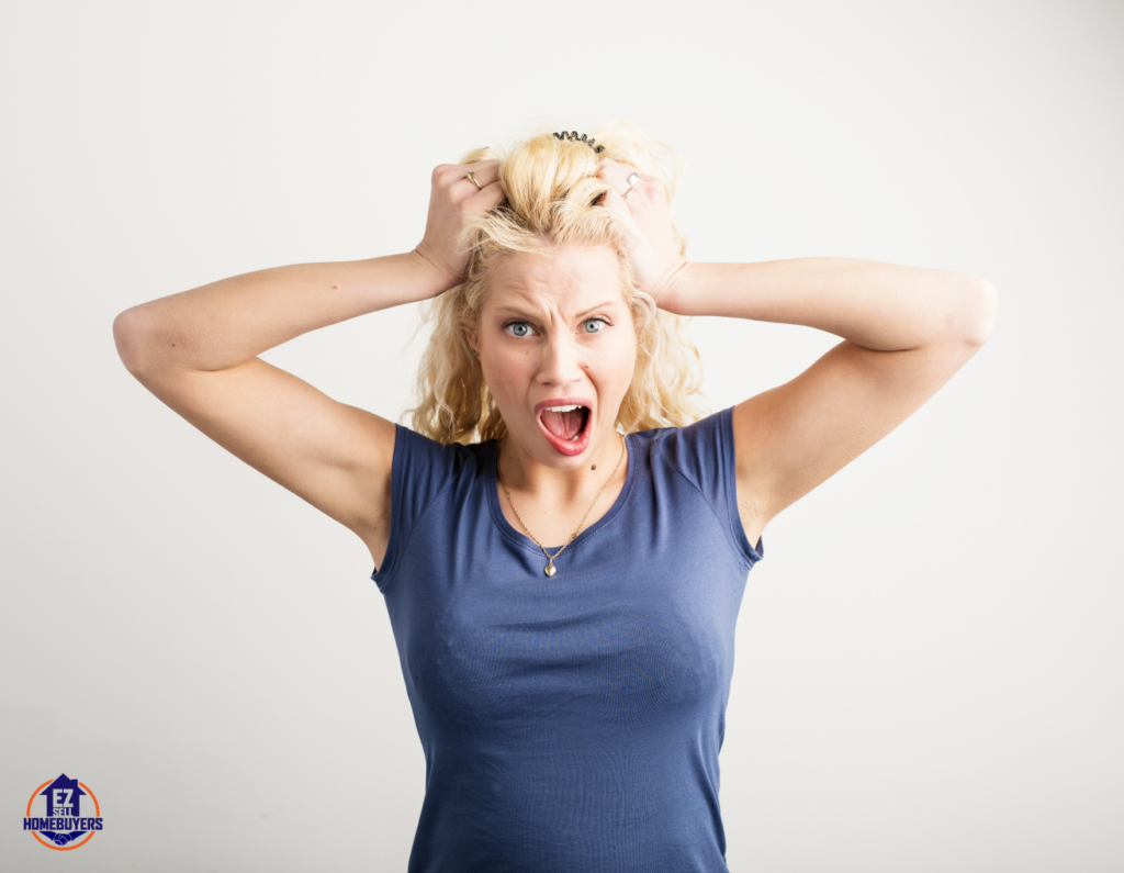 Frustrated woman pulling her hair, representing the stress of a house not selling in Ohio, with solutions including pricing strategies, home appeal improvements, and alternative selling methods.