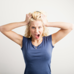 Frustrated woman pulling her hair, representing the stress of a house not selling in Ohio, with solutions including pricing strategies, home appeal improvements, and alternative selling methods.