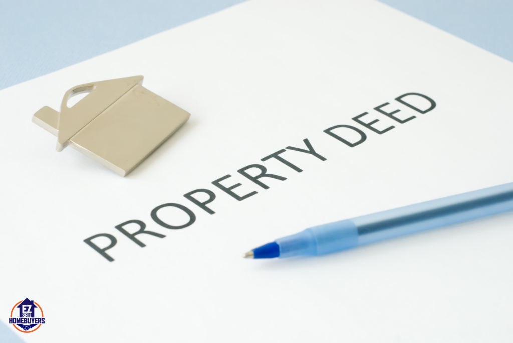Property deed document with a house-shaped keychain and a pen, representing the process of removing a person's name from a deed in Ohio.