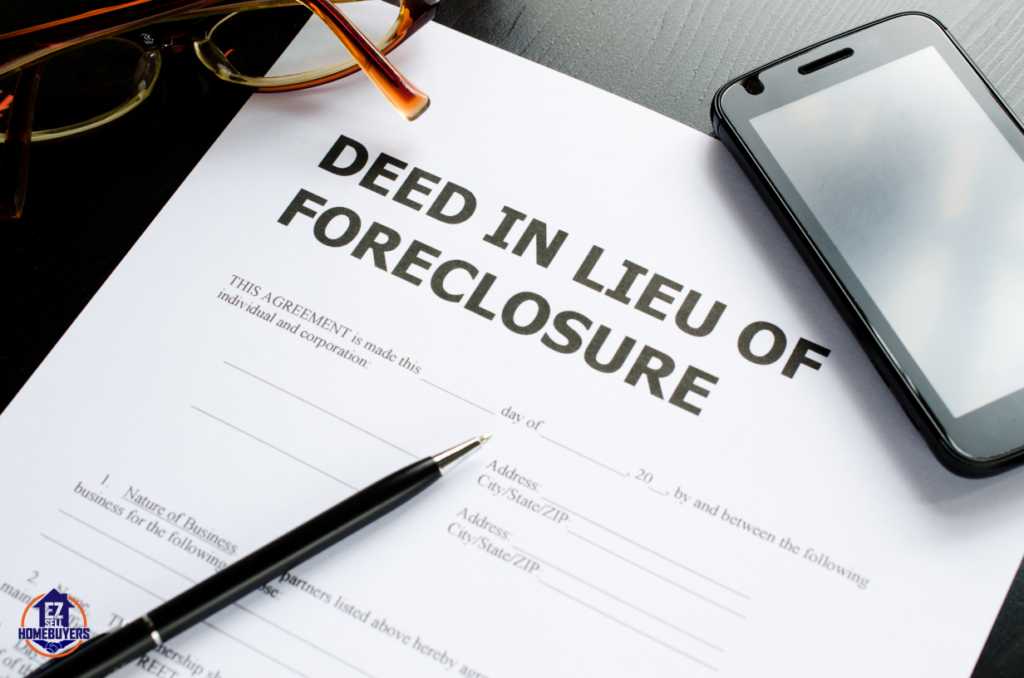 Deed In Lieu of Foreclosure document with pen, phone, and glasses on a table, representing the process of avoiding foreclosure in Ohio.