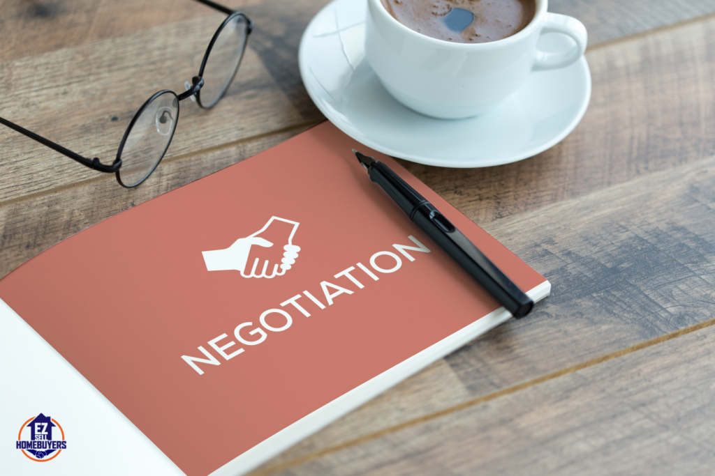 Notebook with the word 'Negotiation' on the cover, pen, eyeglasses, and coffee cup on a wooden table, symbolizing strategies for handling offer negotiations when selling a house in Ohio.