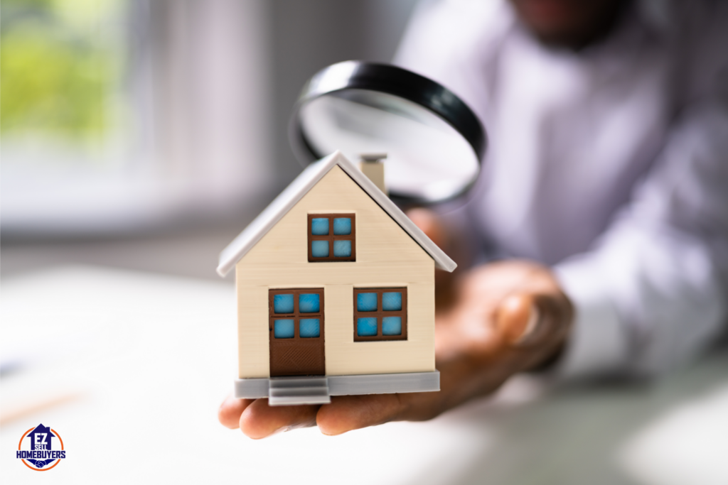 Close-up of a miniature house being inspected with a magnifying glass, representing the Ohio home inspection process. Ideal for real estate buyers or sellers needing home inspection tips.