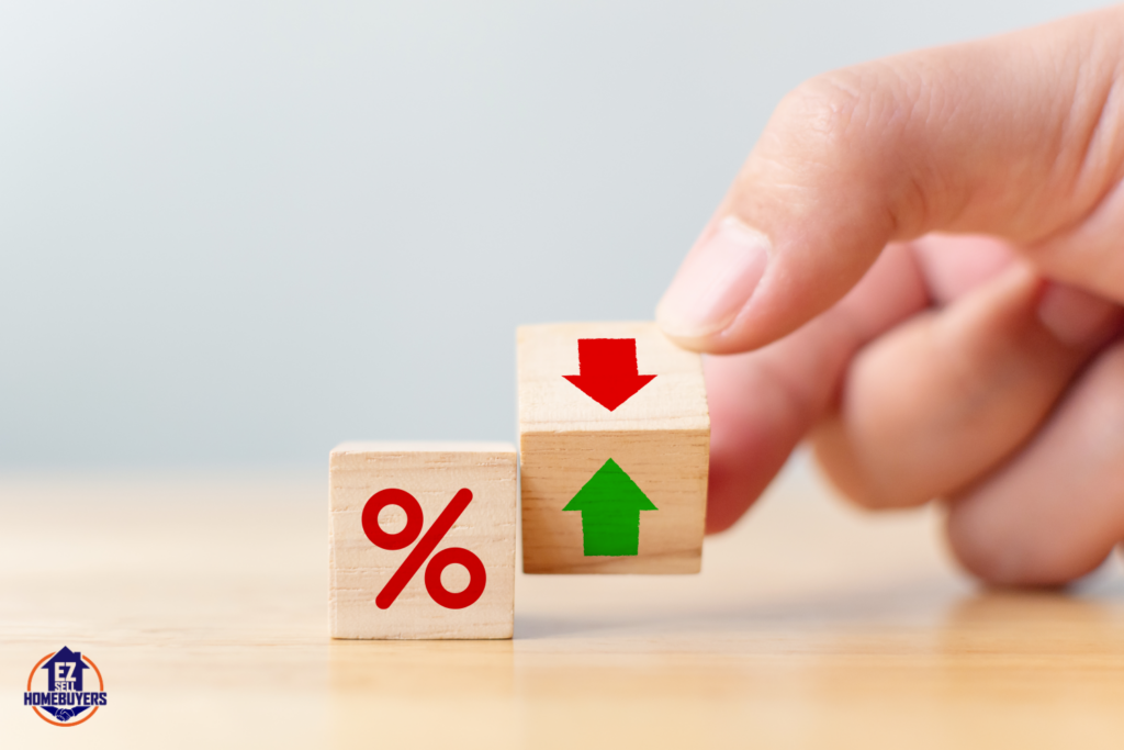 Hand adjusting wooden blocks with percentage symbol and up/down arrows, symbolizing fluctuating interest rates and their impact on the Ohio housing market in 2024.