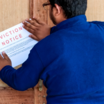 A landlord posting an eviction notice on a wooden door, demonstrating the first step in the eviction process in Ohio without a lease. The notice outlines the legal requirements for tenants to vacate the property, highlighting compliance with Ohio landlord-tenant laws.