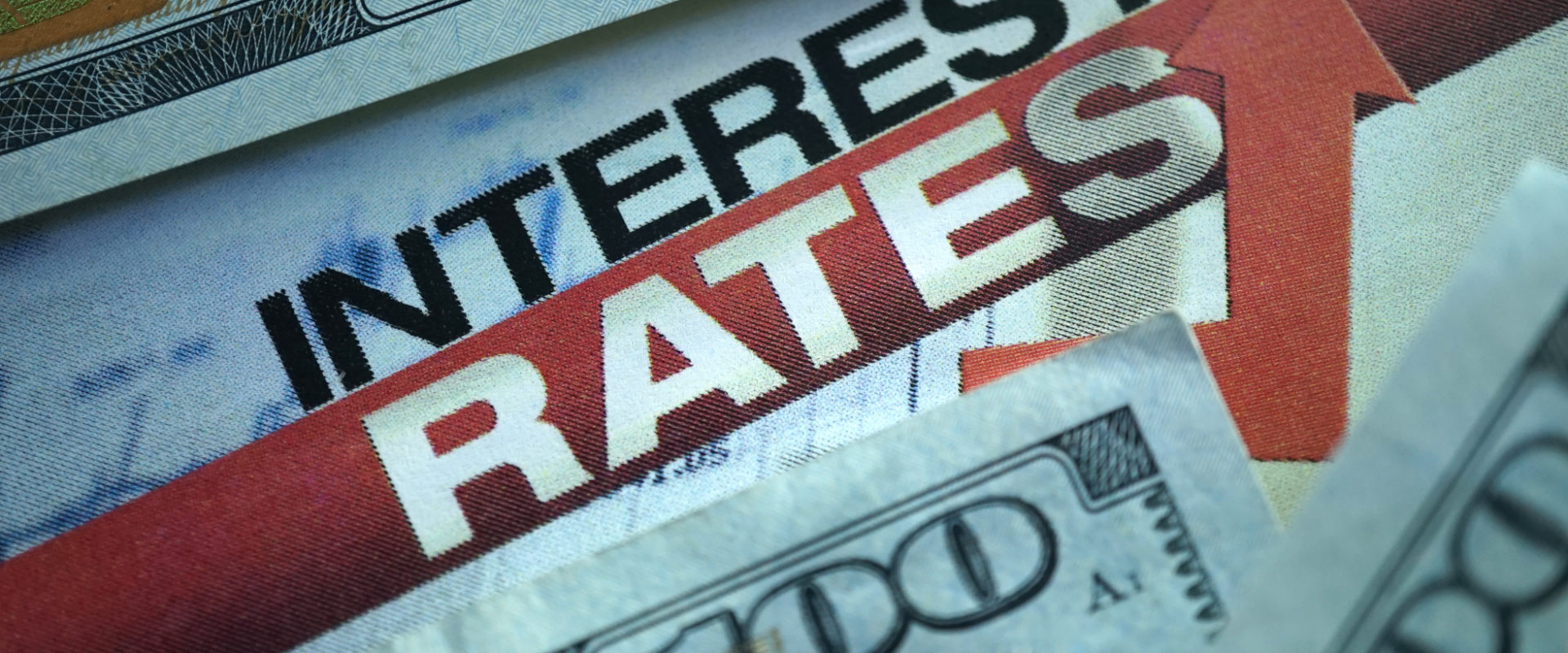 Rising interest rates concept with U.S. hundred-dollar bills and an upward red arrow on a financial newspaper. Mortgage rates in Ohio remain high due to Federal Reserve policies and inflation. EZ Sell Homebuyers logo included.