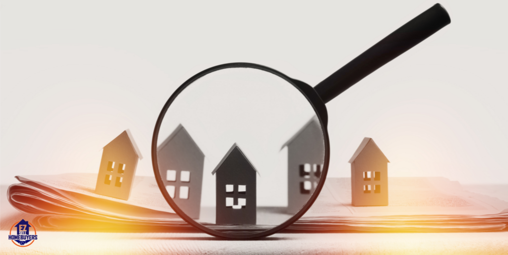 Magnifying glass over paper houses symbolizing analysis of Ohio real estate market trends and the impact of tariffs on housing and construction costs.