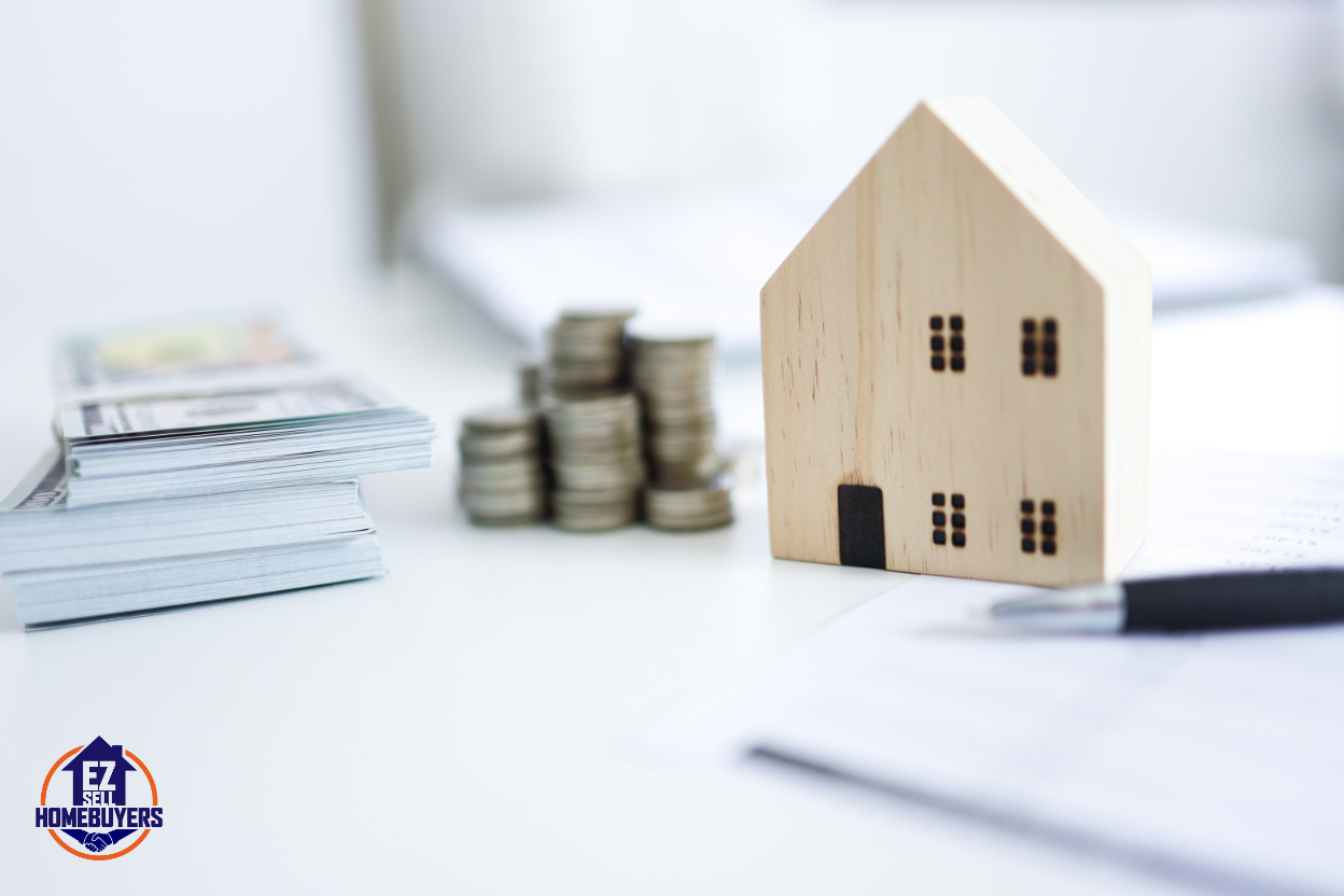 Mini wooden house model beside stacked coins symbolizing real estate investment growth and home value in Dayton, Ohio