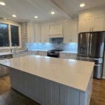 Finished kitchen remodel in Vienna, Virginia: white shaker cabinets, a large quartz island and wood floors