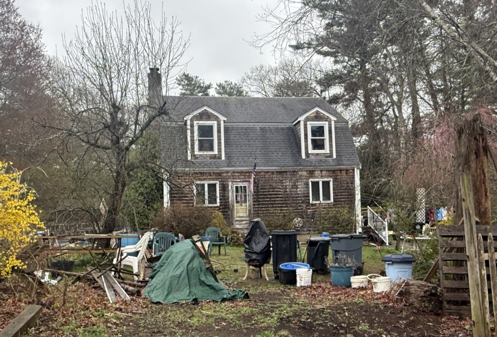 Distressed brown shingled house with cluttered yard in Halifax MA – sell house as is Halifax Massachusetts