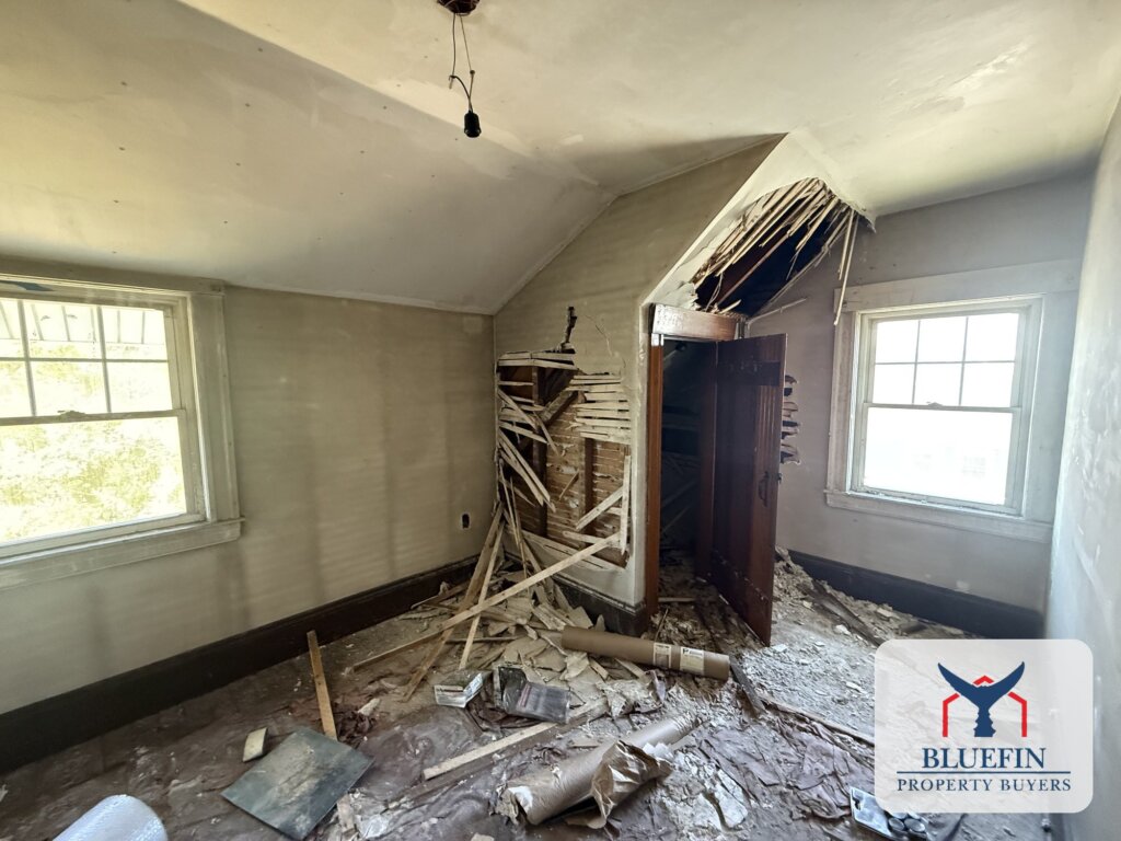 Upstairs bedroom with plaster and lath torn from the wall during fire overhaul in a Massachusetts home