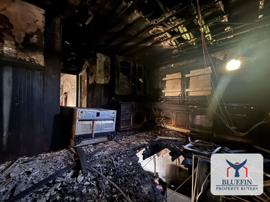 Burned kitchen cabinets and range in a Massachusetts home where the fire started underneath in the basement