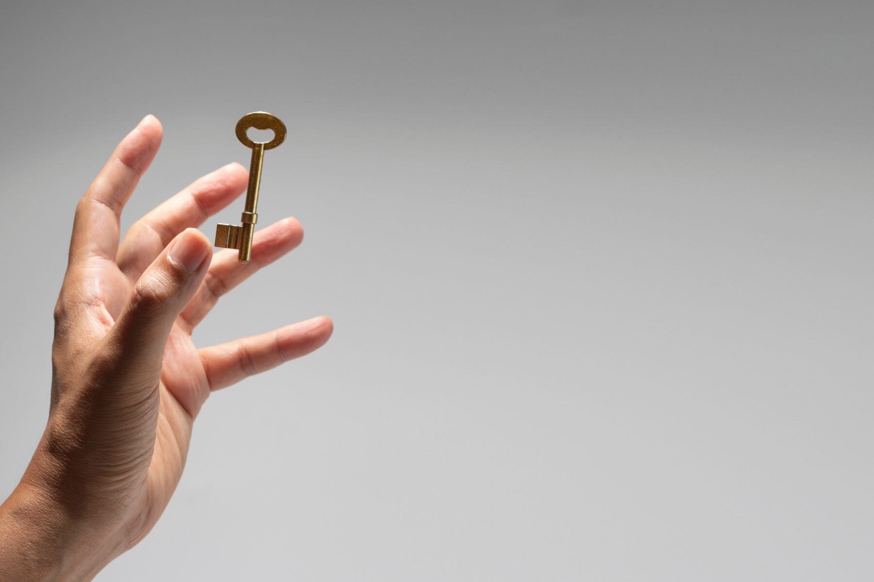 Hand holding an old-style key, symbolizing unlocking financial potential and investment opportunities.