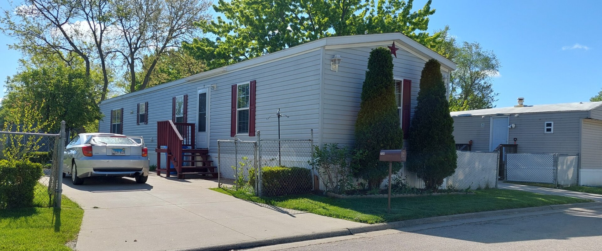 Mobile home with driveway in Illinois residential community.