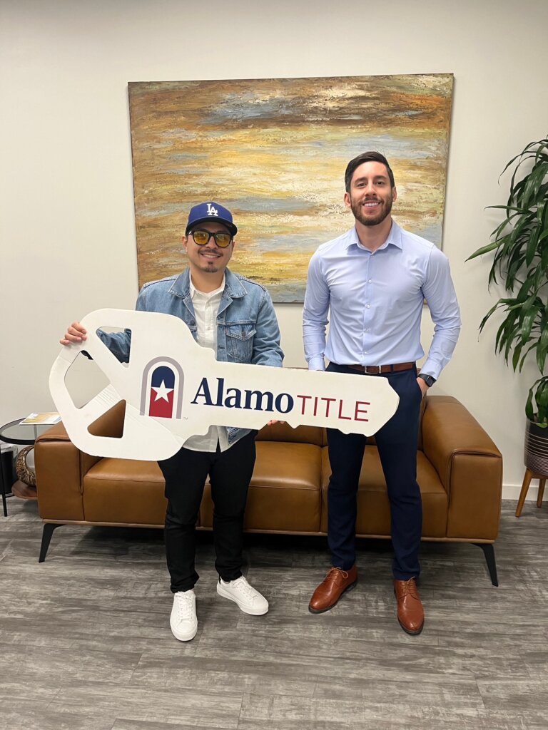 Real estate partners with Alamo Title key after Texas housing market property purchase.