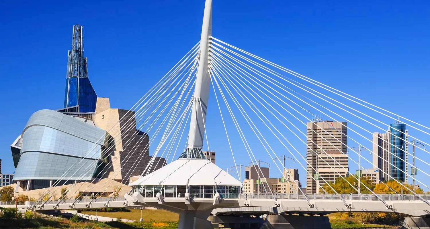 Winnipeg skyline featuring Esplanade Riel pedestrian bridge and Canadian Museum for Human Rights on a clear day in downtown Winnipeg Manitoba