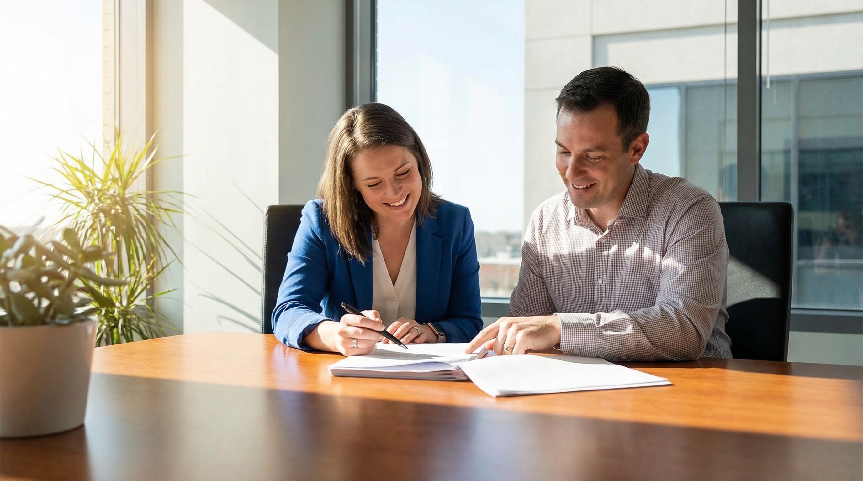 Two people reviewing real estate closing documents at a table