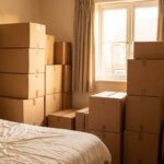Packed cardboard moving boxes neatly stacked in a bedroom