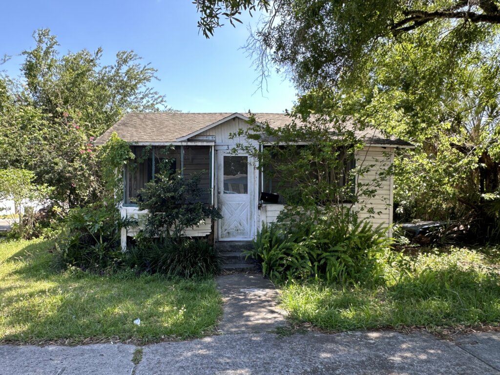 Exterior photo of a house A+ Home Buyers purchased in Tampa FL.  House looks to need some serious remodel. 