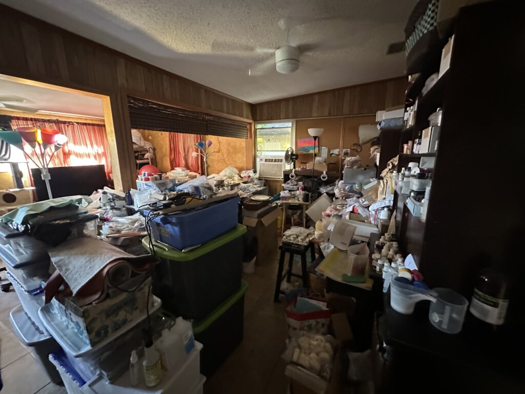 Interior photo of the house A+ Home Buyers purchased from Terry and Del.  Living room photo with trash everywhere.  