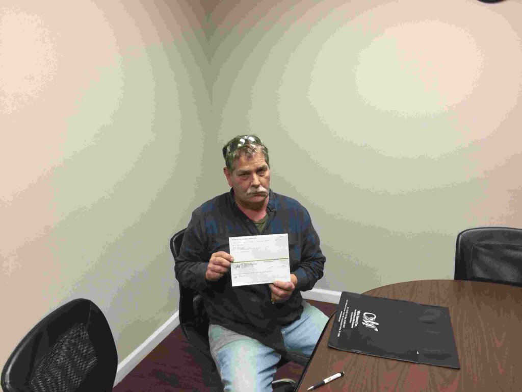 Edward holding closing check from Jeff Buys Houses Cash