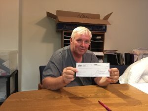 Robert holding check after closing on the sale of his house with Jeff Buys Houses Cash.