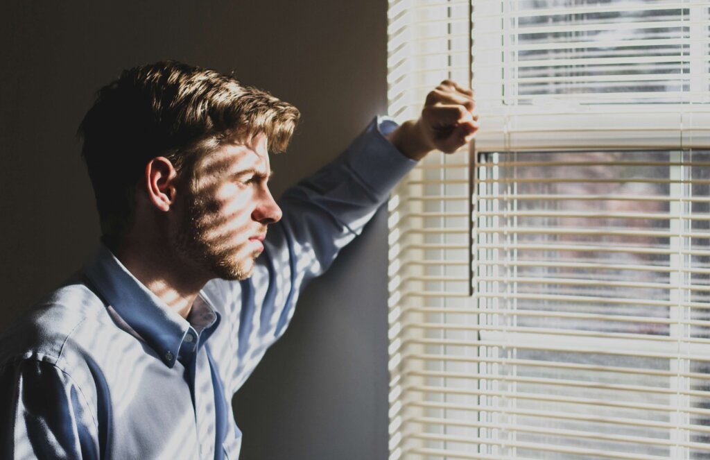 Man looking out of window of his house facing divorce