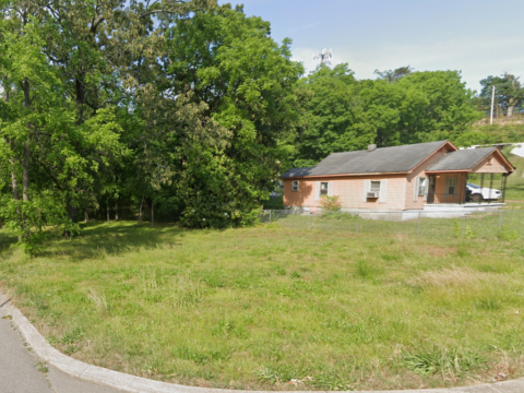 Flat residential land with adjacent rental house, showing spacious and level terrain in Chattanooga, TN