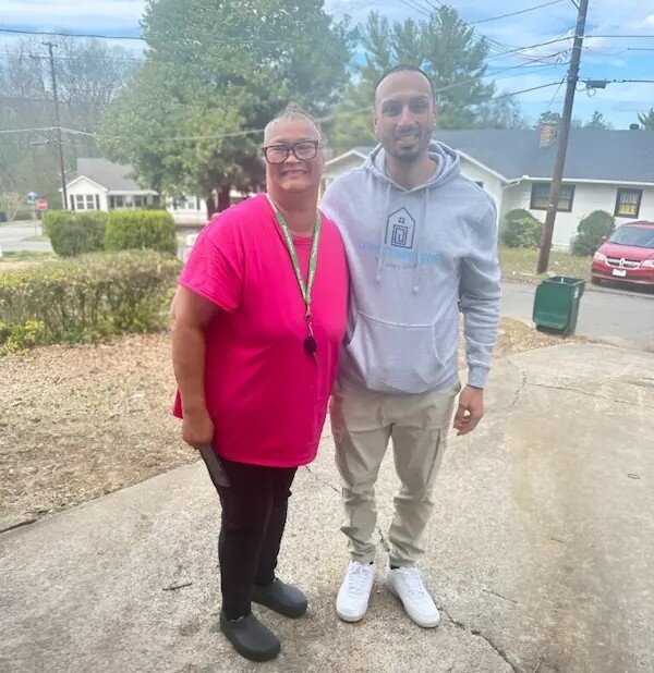 Smiling older woman standing in front of her recently sold home in Chattanooga, TN