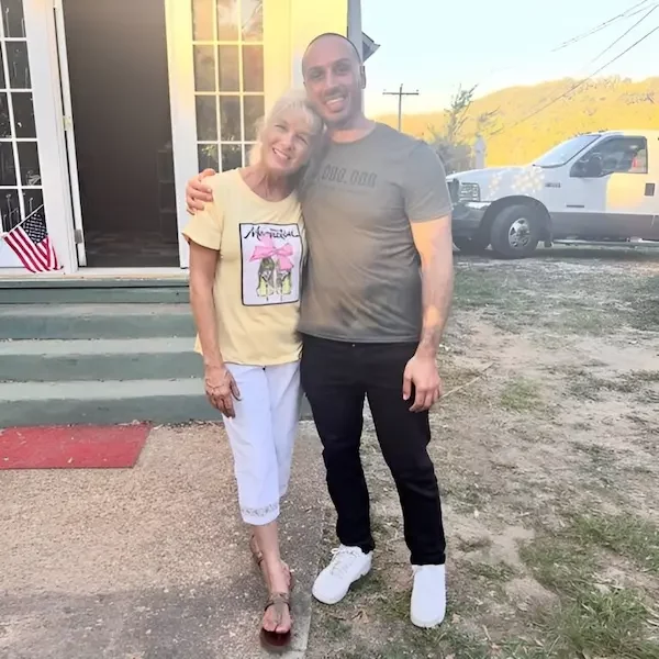 Smiling woman from East Ridge posing in front of her multifamily four-unit home in Chattanooga, TN