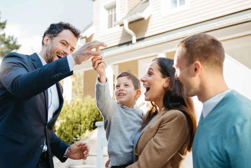 Happy family receiving house keys from a real estate agent.