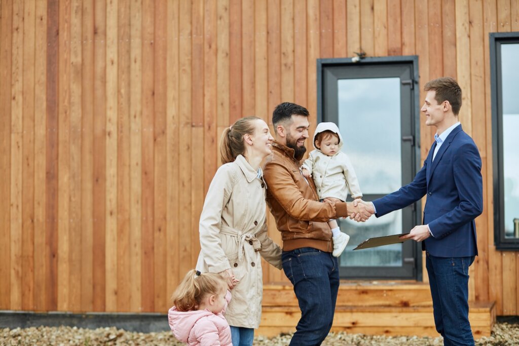 Happy Family at House Shaking Hands with Man in Blue Suit Jacket on Longmont Colorado Web Page