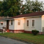 white and brown mobile home near green trees during daytime