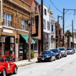 Traditional main street lined with small businesses and parked cars, showcasing a vibrant community ideal for commercial real estate investment.