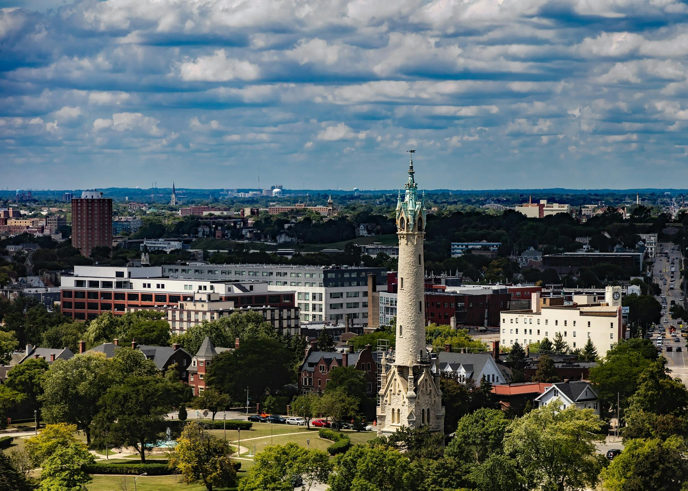 Elevated view of a city landscape with a prominent historical tower and surrounding residential areas, emphasizing the diverse real estate options available in an urban setting.