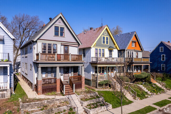 A row of charming two-story homes with colorful exteriors in a Milwaukee neighborhood, showcasing the unique architectural style of the area.