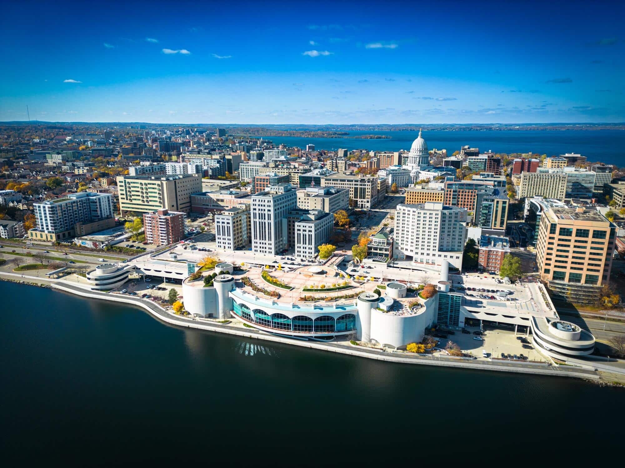  Aerial view of downtown Madison, Wisconsin, showcasing the Monona Terrace Convention Center, state capitol, and surrounding cityscape by Lake Monona.