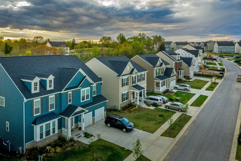 New suburban neighborhood with houses, driveways, and tree-lined streets.