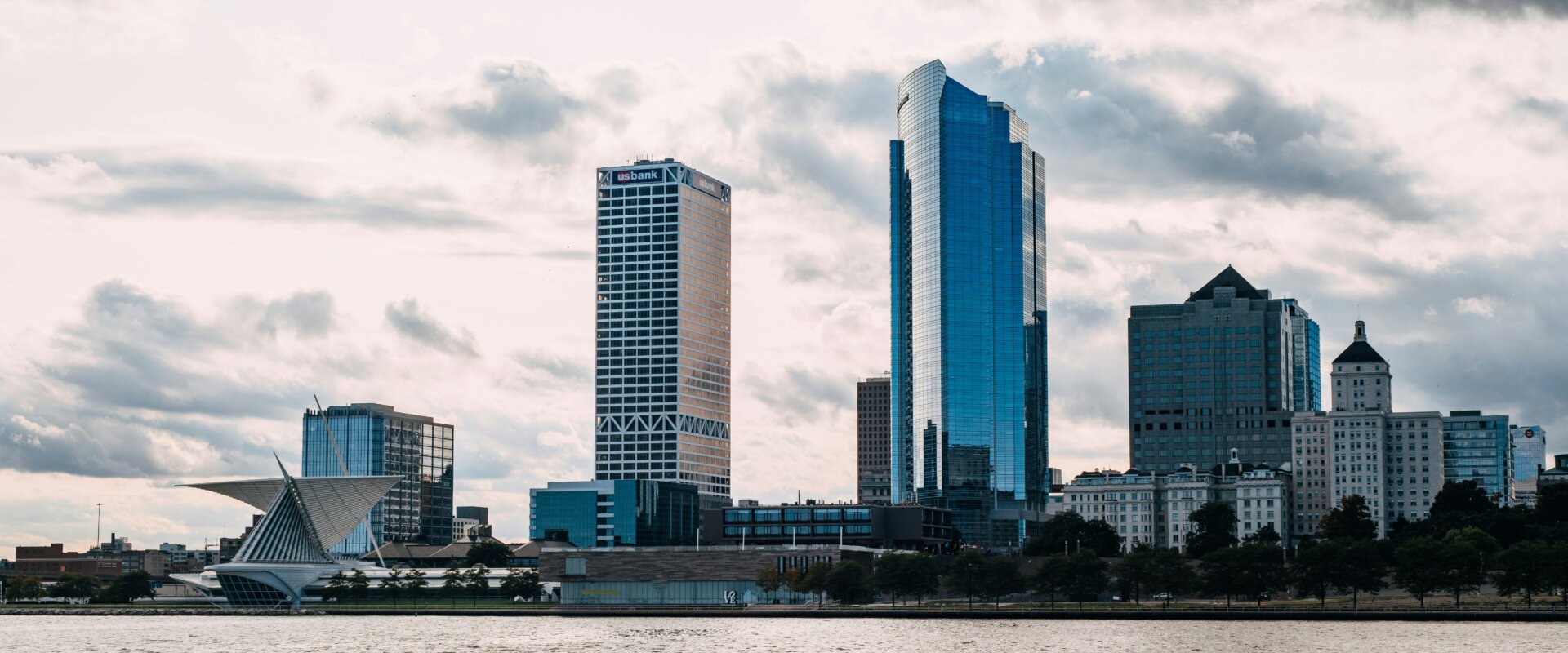 Milwaukee skyline with modern buildings and the Milwaukee Art Museum by the waterfront.