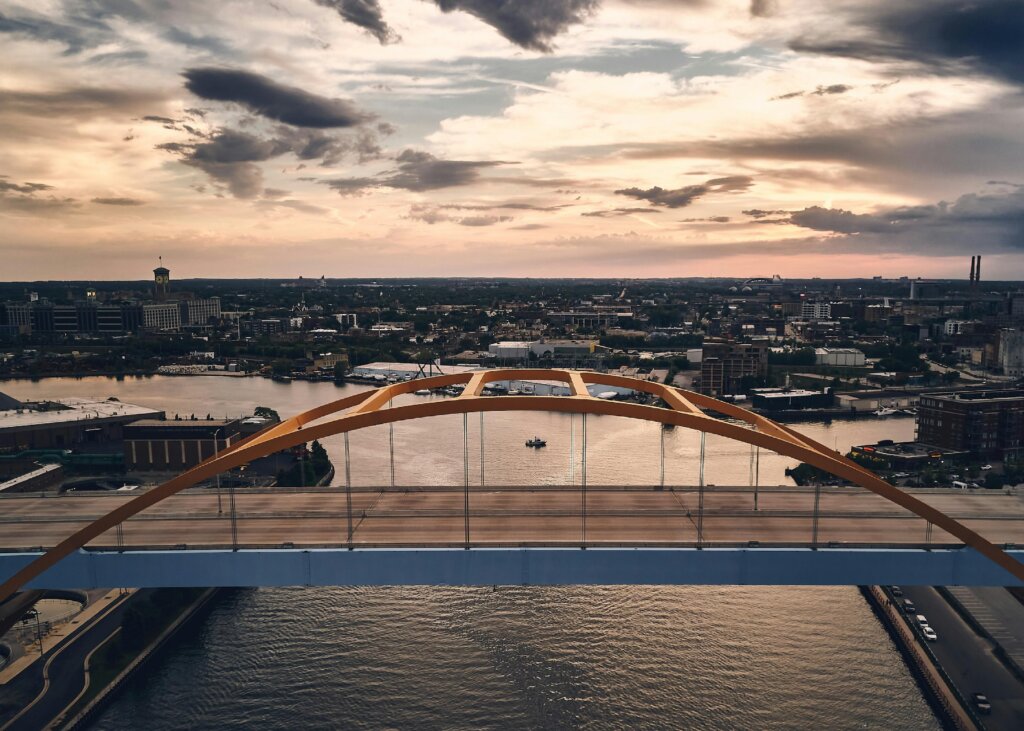 Panoramic view of Milwaukee city skyline with a bridge in the foreground during sunset.