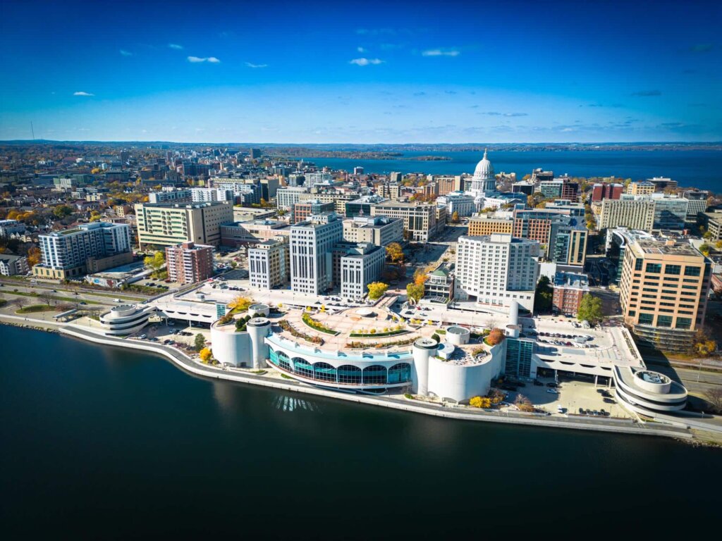 Aerial view of downtown Madison with the Wisconsin State Capitol and Lake Monona in the background.