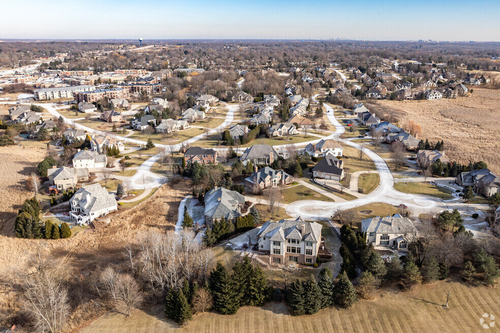 Aerial view of a suburban neighborhood in Brookfield, Wisconsin, showcasing winding streets, large homes, and open green spaces with a mix of modern and traditional architecture.