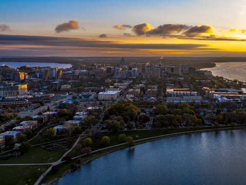 Aerial view of downtown Madison, Wisconsin, at sunset, with the state capitol and surrounding landscape.