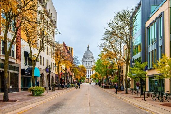Downtown Madison with autumn trees and the Wisconsin State Capitol in the background.