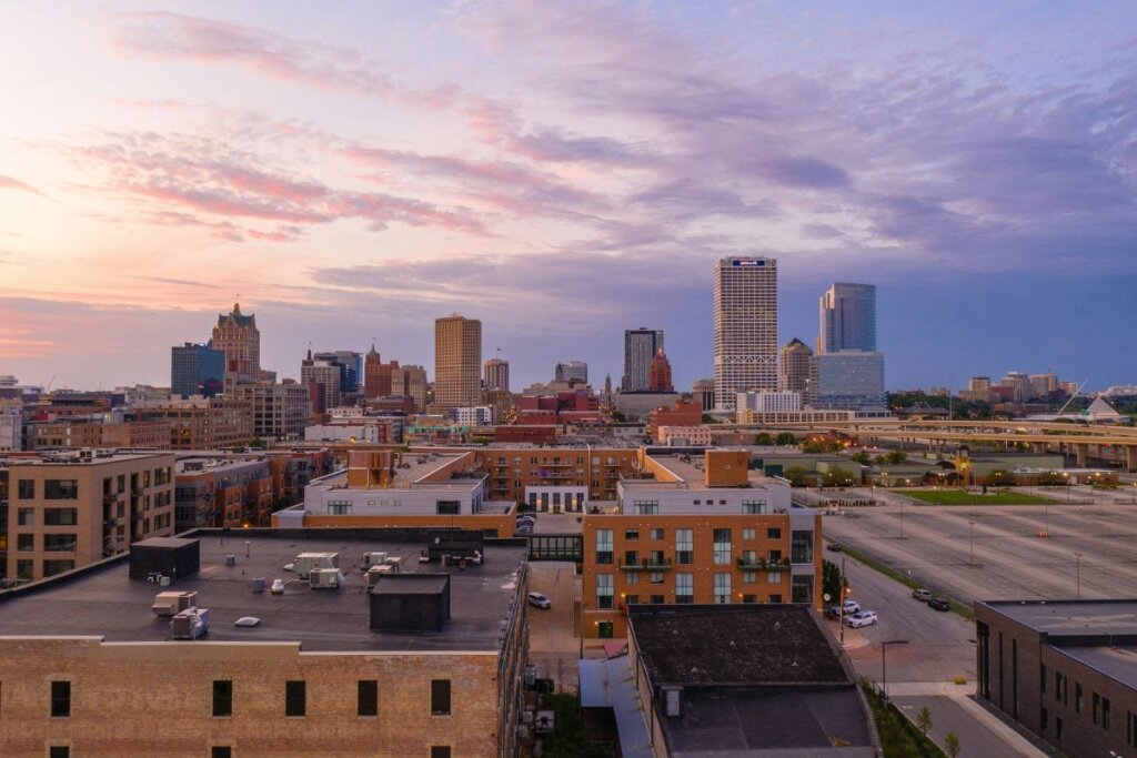 Milwaukee skyline at sunset with city buildings and waterfront.
