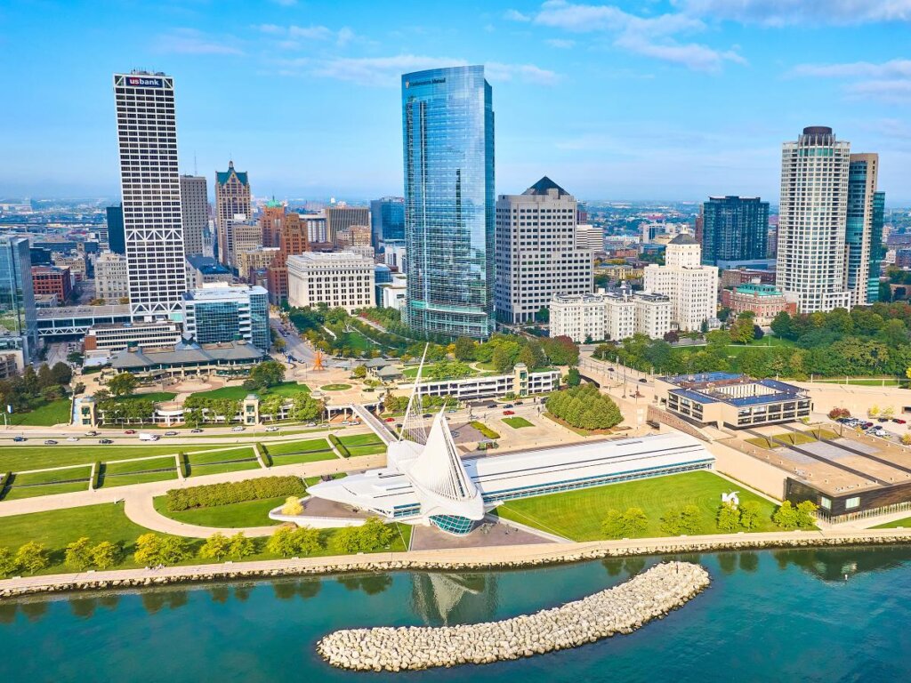 Aerial view of downtown Milwaukee, Wisconsin, featuring the Milwaukee Art Museum by Lake Michigan and modern high-rise buildings in the skyline.