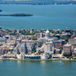 Aerial view of downtown Madison, Wisconsin, with the State Capitol and Lake Monona in the background.