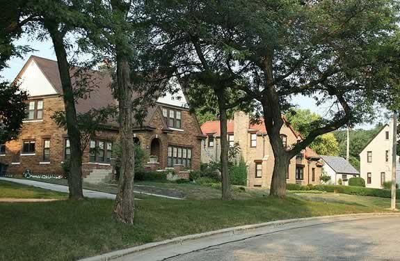 Tree-lined residential street in Wauwatosa featuring classic brick homes and well-maintained lawns.