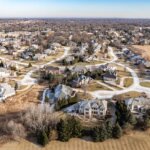 A scenic view of Brookfield, Wisconsin featuring a peaceful suburban neighborhood with trees, houses, and clear skies.