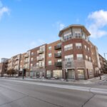 Primary exterior view of Six Points Apartments in West Allis, WI, showcasing a modern multi-story residential building with clean architectural lines.