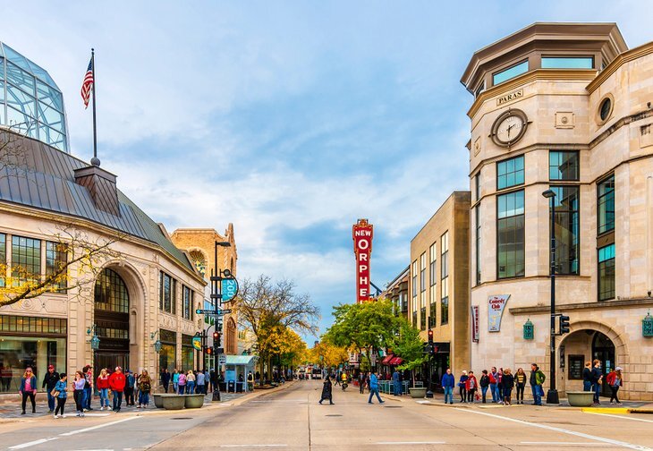 Downtown Madison, Wisconsin with people walking near shops and the New Orpheum Theater sign in view.